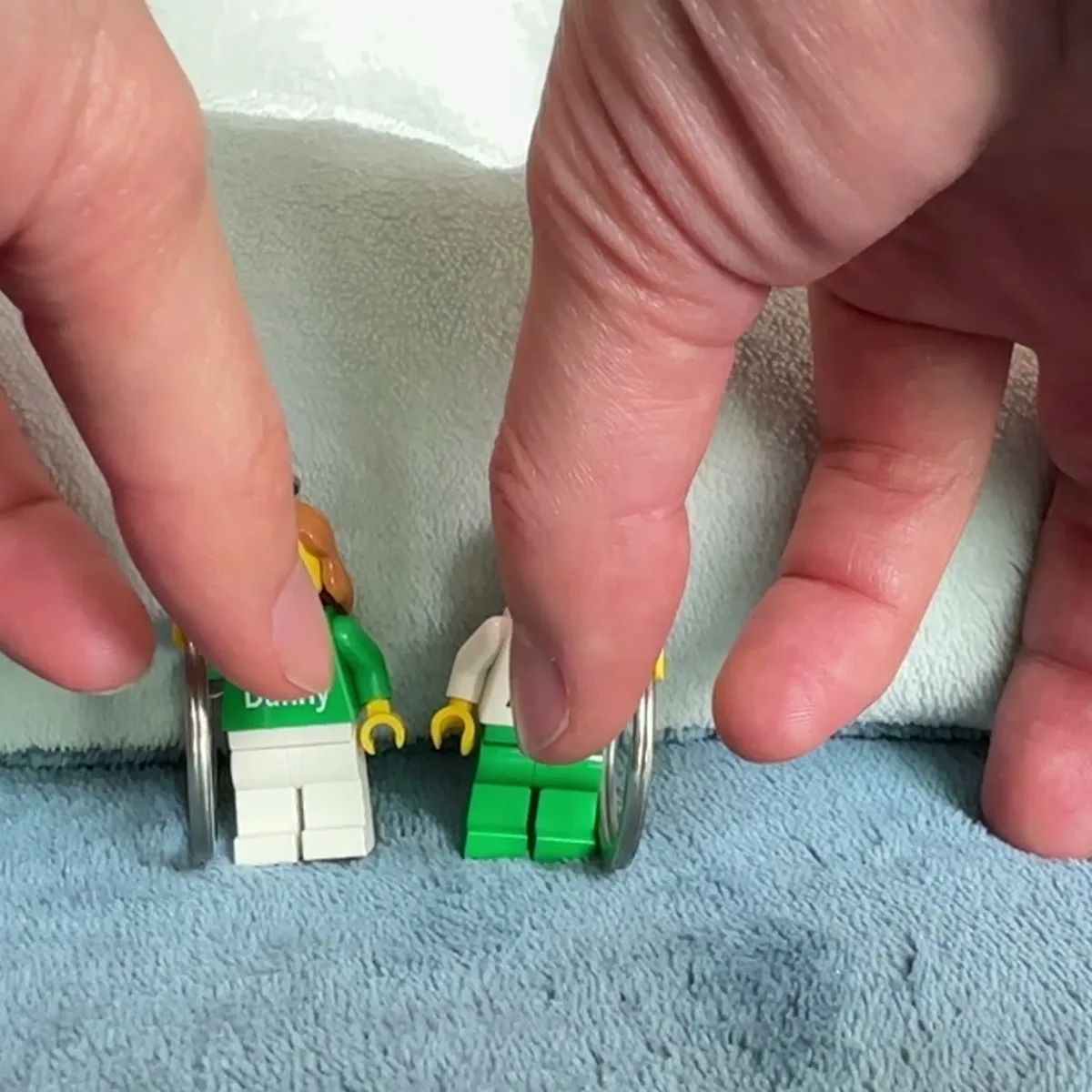 Hands assembling a personalized brick figure by hand